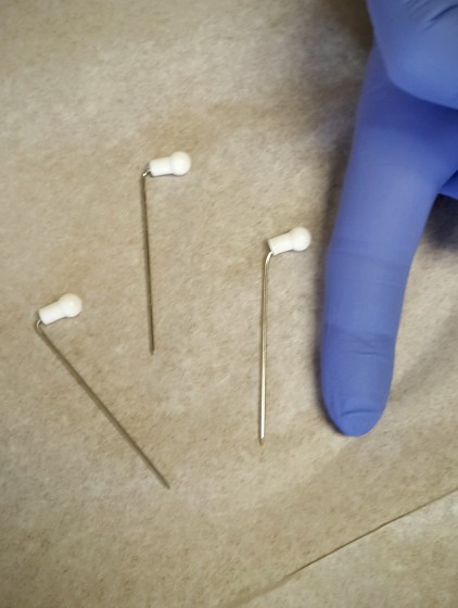These are the pins that were in my toes with the nurse's finger for scale.