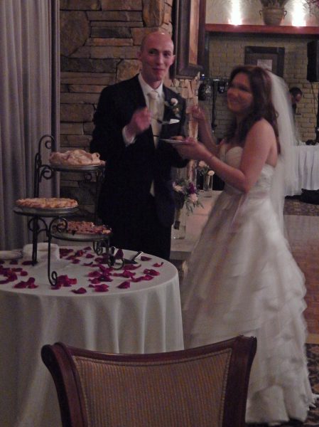 The bride and groom sharing a piece of wedding pie