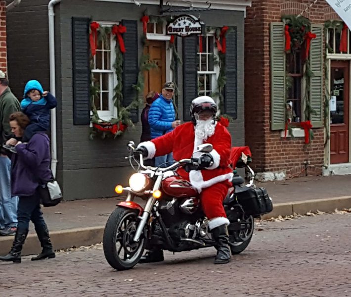 This might be a modern Santa. I don't think it's a "period" motorcycle. Notice the trimmings on the shops in the background. The whole street is decorated like this.