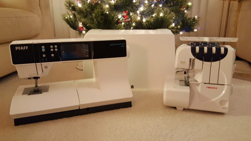 Sewing machine on the left; its case in the back; serger on the right.